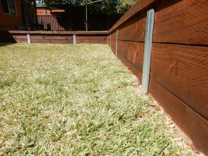 Treated timber pine retaining wall coated in Sikkens Cetol HLSe Dark Oak